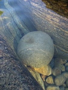 big smooth rock in water